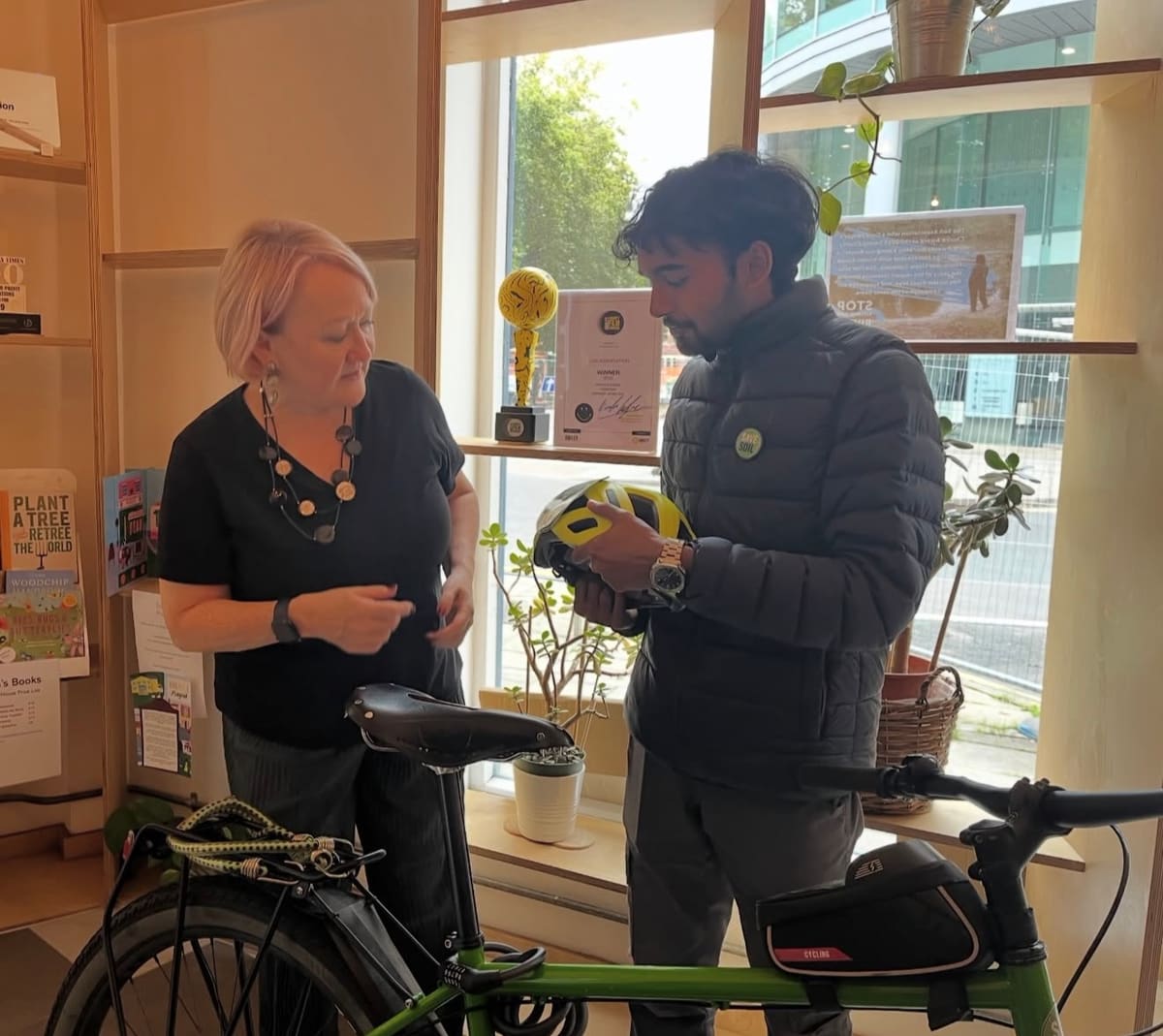 Sahil Jha showing his Save Soil helmet and bicycle to Kerry McCarthy