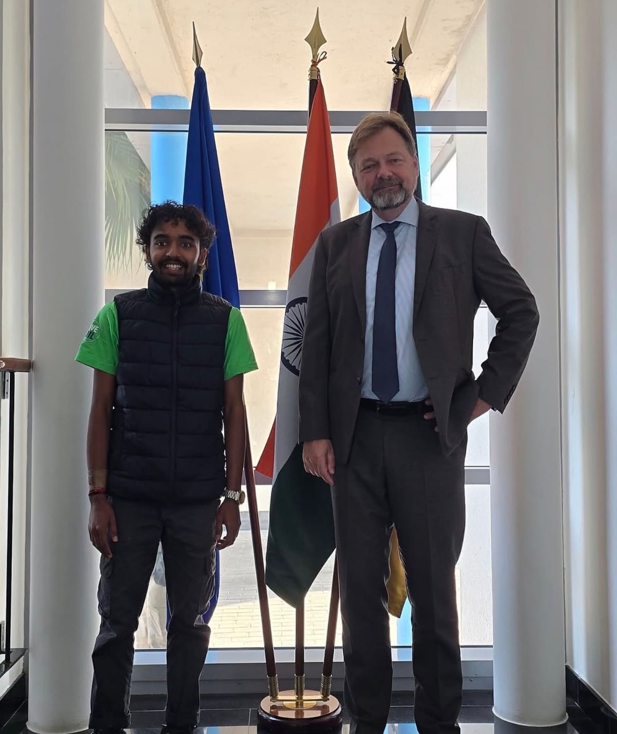Sahil Jha with Philipp Ackermann in front of the EU, Indian and German flags