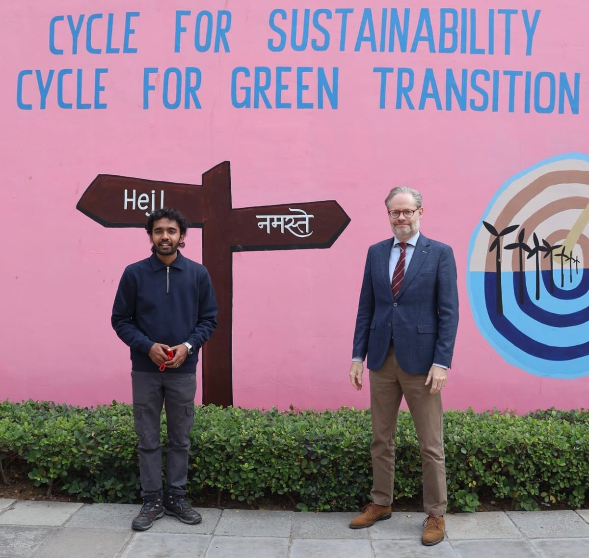Sahil Jha with Rasmus Abildgaard Kristensen in front of a “Cycle for Sustainability” mural